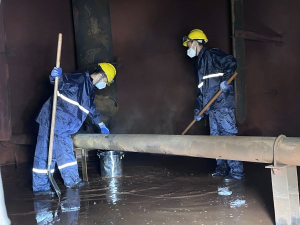 將熱水槽底部污水鏟倒廢桶中，用廢桶搬運出去.jpg